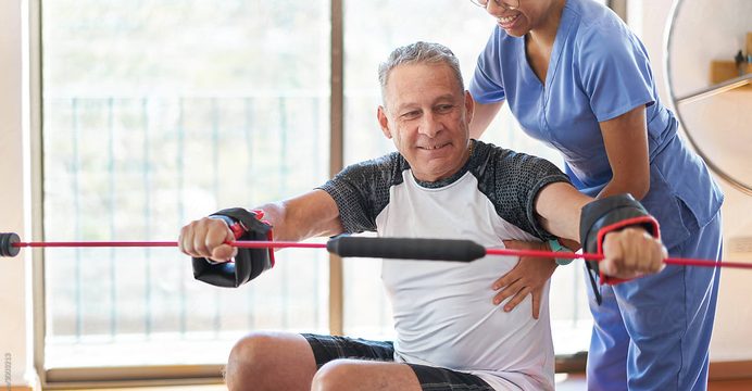 Therapist working with a resident using a resistance band