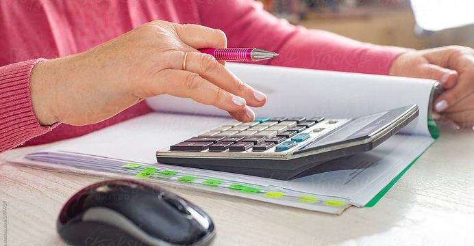 Hands working through bills with a calculator