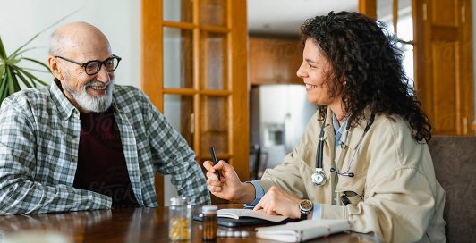 Clinician talking with an older man at a table