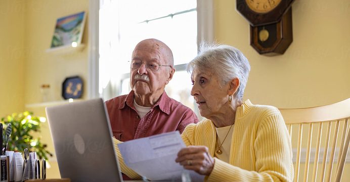 Older couple reviewing a statement together at the kitchen table