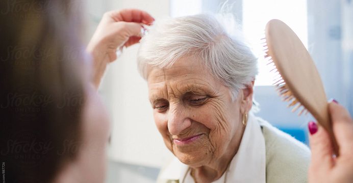 Caregiver gently brushing a resident's hair
