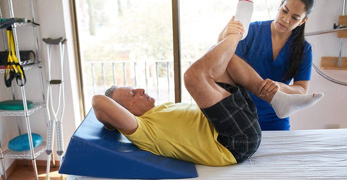 Therapist guiding a resident through a hip stretch