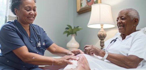 Nurse caring for a resident’s leg at the bedside
